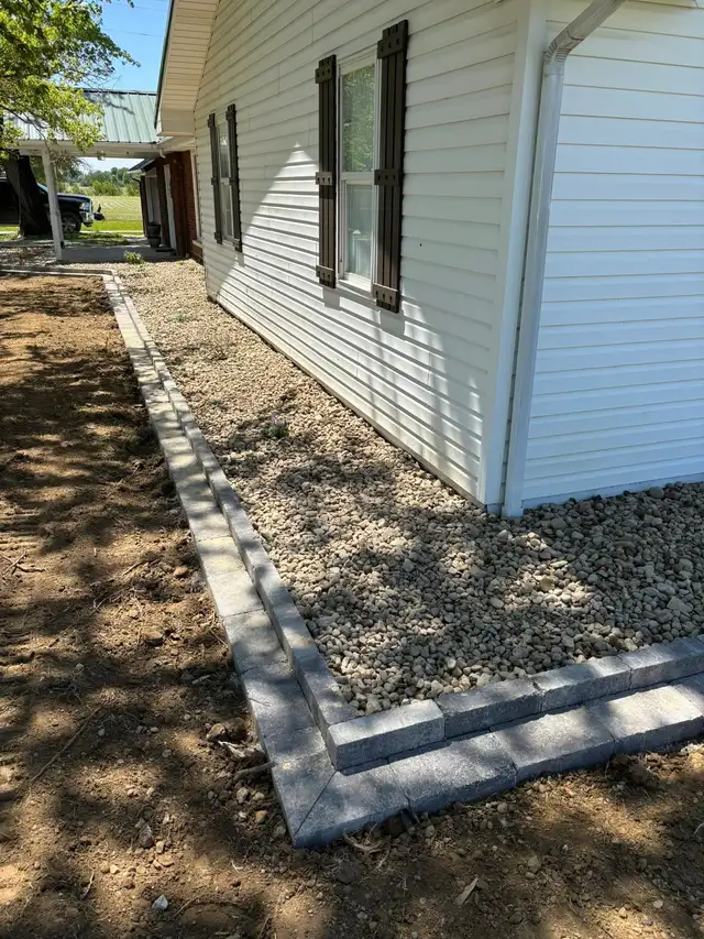 Decorative stone and garden edging around a building corner.
